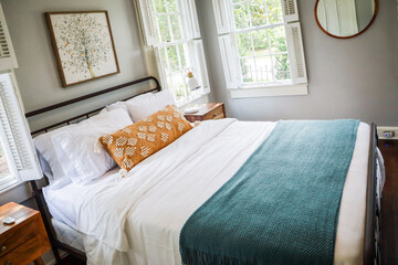 A guest bedroom with a queen sized bed and nightstand at a short term rental small cottage style...