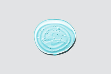 Light blue transparent round gel drop isolated on white background. Top view. Virus protection or cosmetics concept. Face Serum texture close up.