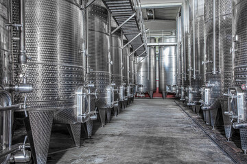 Steel wine tanks for wine fermentation at a winery. modern wine factory with large shine tanks for the fermentation.