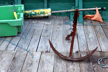 Old fishing boat equipement: fishing nets, fish boxes inside, buoys, anchors, ropes