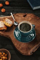 Hot Coffee in Rustic Cup with on Wood Surface with Book and Pastry