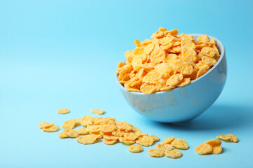 Delicious cornflakes in a plate against colored background. 