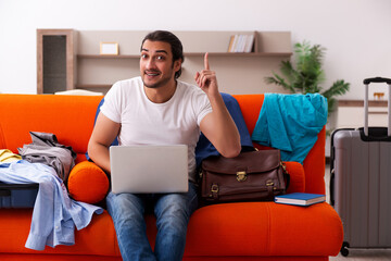 Young man student preparing for trip at home