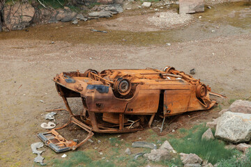 Fototapeta premium Rusty, overturned car. A car abandoned after an accident.