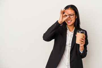 Fototapeta premium Young business latin woman holding a take away coffee isolated on white background excited keeping ok gesture on eye.