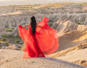 woman in red dress in Cappadocia Turkey, desert landscape