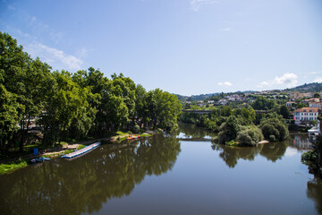 Fototapeta premium River reflecting the trees in the center of Amarante