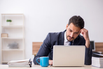 Young male employee sitting at workplace