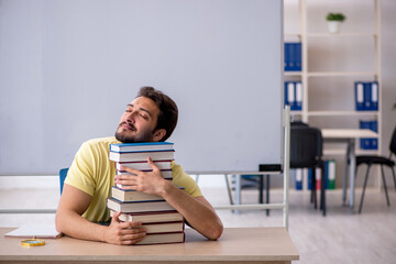 Young male student preparing for exams in the classroom