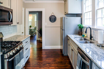 A small cottage kitchen with gray cabinets and dark hardwood floors in a short-term rental house
