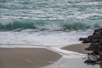 Welle am Strand mit Felsen