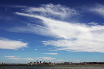 Obraz premium San Francisco under blue sky with Alcatraz and the Oakland Bay bridge seen from across the water in early August of 2021