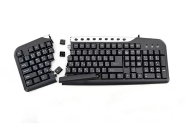 Fotobehang Broken keyboard. Destroyed keyboard. Black PC Keyboard is smashed and broken in half. PC repair shop cleans the keyboard from dust © Эдуард Аверюшкин