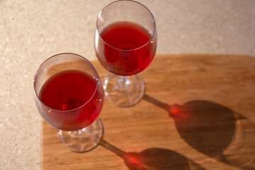 Two glasses of red wine with the shadow of the glasses