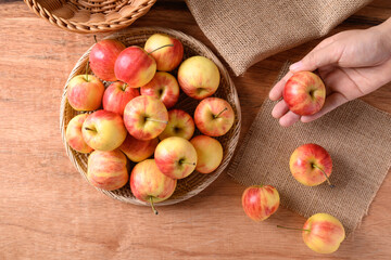 Fresh red apple fruit in a basket on wooden background, Table top view