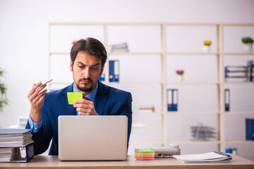 Young male employee sitting at workplace