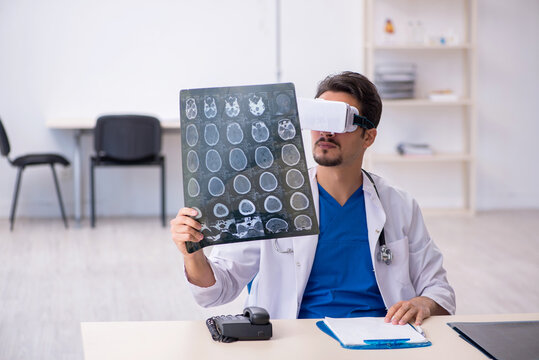 Young male doctor wearing virtual glasses in the clinic