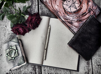 Still life with old decorated book with shabby pages, roses on wooden planks background.