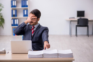 Young male employee sitting at workplace