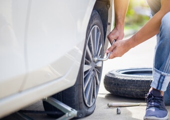 Man changing car tire with wheel wrench on street, Technician fixing tire with wrench, Repairing...