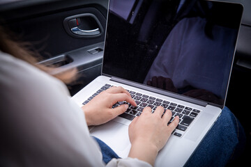 ノートパソコンをひらく女性　助手席で調べ物をする女性　助手席に座る女性