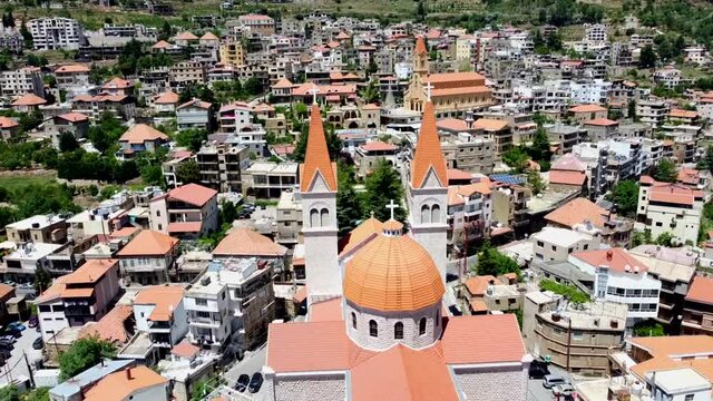 Dome And Spires Of Saint Saba Cathedral With Bsharri Town On A Sunny Day In Lebanon. - aerial