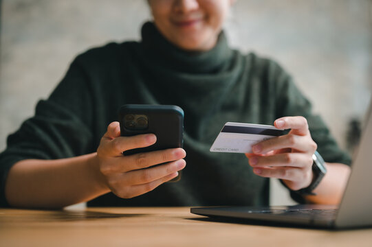 online shopping and E-commerce concept, happy smile Woman hand using smartphone and holding credit card for shopping payment online at home.