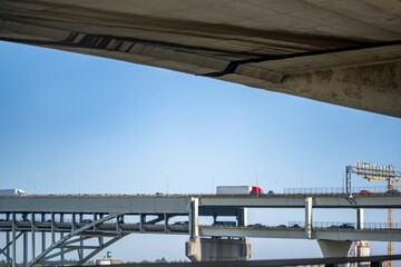 Big rig semi trucks and another cars running on the two level arch Fremont bridge across Willamette river in Portland Oregon