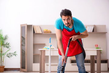 Young male contractor cleaning the house