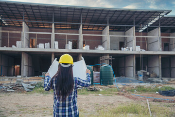 Woman construction engineer hold blueprint wear plaid shirt safety white hard hat at construction site industry labor worker. Architecture Female engineer civil worker look at blueprint real estate
