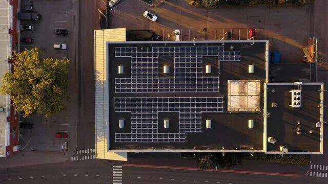 Aerial view above photovoltaic cells on a building roof - descending, top down, drone shot