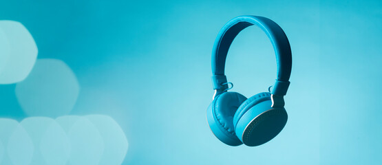 Auriculares de color celeste en fondo liso de estudio