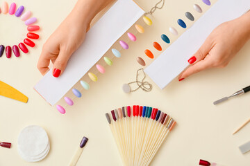 Female hands with nail polish tips on color background