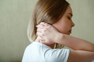 Woman holds neck with pain cervical muscle spasm by hand. Neck pain, cervical vertebrae, Disease of...