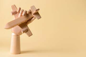 Hand with wooden airplane on color background. Concept of hostage