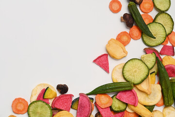 Dried vegetables chips with green radish, okra, carrots, pumpkin, beetroot and shiitake mushrooms on white background.