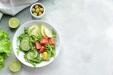 Plate with fresh salad on light background