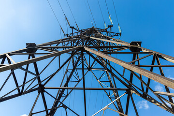 Rusty power line is on the blue sky background