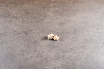 Fresh champignon mushrooms on grey background.