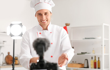 Handsome chef recording video in kitchen