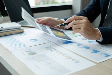 The hand of businessman sit at their desks and calculate financial graphs showing results about their investments, plan a successful business growth process