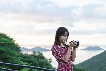 夕暮れの観光地で撮影をするカメラ女子