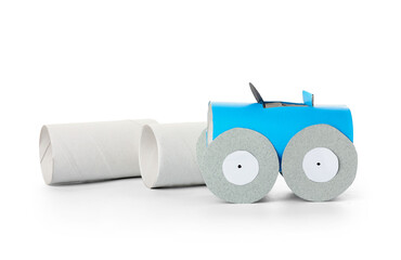 Car made of cardboard and tubes for toilet paper on white background