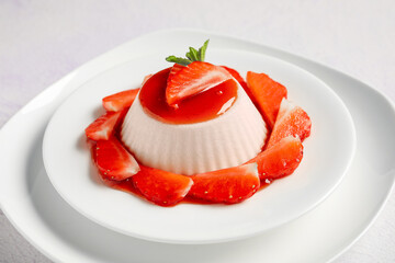 Plate with tasty strawberry panna cotta on white background, closeup