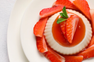 Plate with delicious strawberry panna cotta on light background, closeup