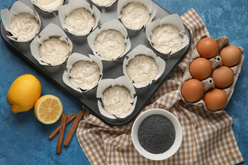 Baking tin with uncooked poppy seed muffins on table