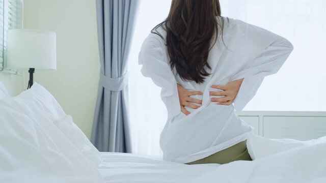 Asian beautiful sick girl in pajamas getting up from sleep in bedroom. 