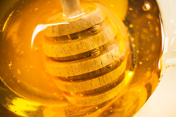 Macro honey. Healthy organic honey with wooden honey dipper closeup.