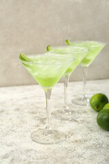 Glasses of tasty daiquiri cocktail on light background
