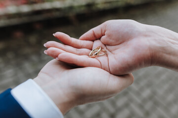 Goldene Eheringe in Händen von Brautpaar